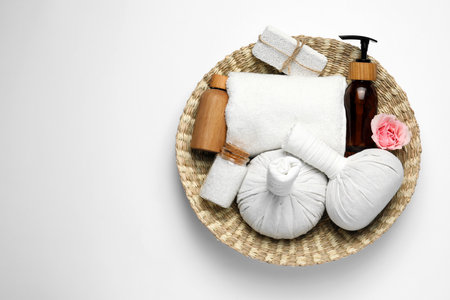 Beautiful spa composition with herbal massage bags and different care products on white background, top view. Space for textの写真素材