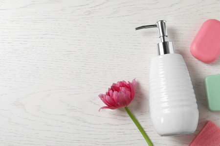 Soap bars, dispenser and tulip on white wooden table, flat lay. Space for textの写真素材