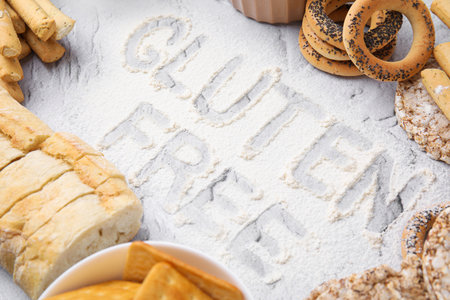 Different products and phrase Gluten free written with flour on light gray tableの写真素材