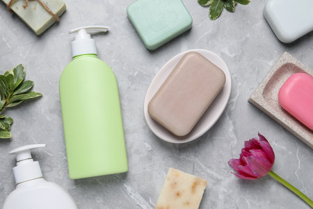Flat lay composition with many different soap bars and bottle dispensers on light gray tableの写真素材
