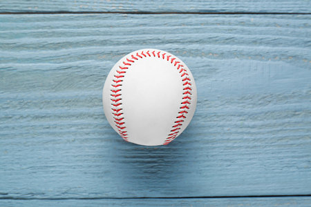 Baseball ball on gray wooden table, top view