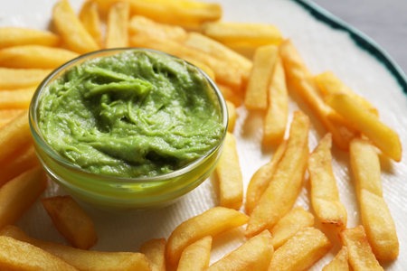 Plate with french fries and avocado dip on black table, closeupの写真素材