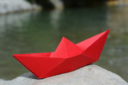 Beautiful red paper boat on stone outdoors, closeupの写真素材