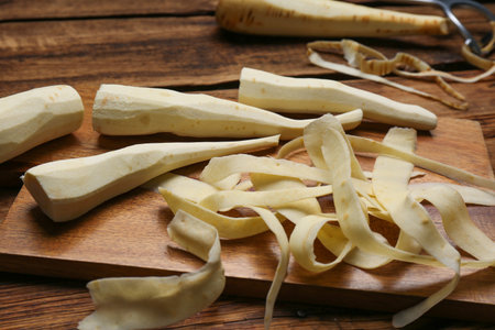 Peeled fresh parsnips and strips on wooden tableの写真素材
