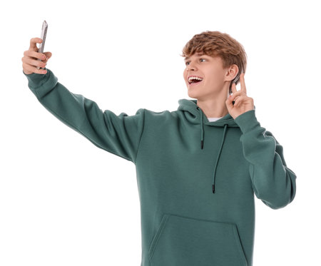 Teenage boy taking selfie on white backgroundの写真素材