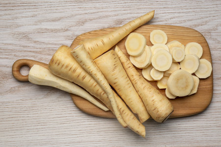 Whole and cut fresh ripe parsnips on white wooden table, top viewの写真素材
