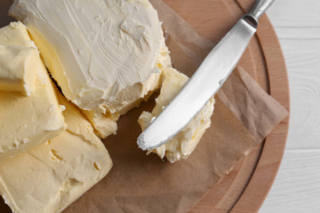 Tray with tasty homemade butter and knife on white wooden table, top viewの写真素材