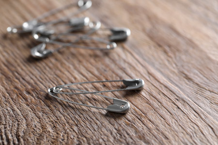 Many safety pins on wooden table, closeup. Space for textの写真素材