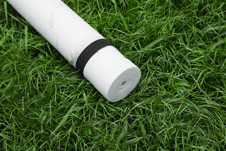 White karemat or fitness mat on green grass outdoors, above viewの写真素材