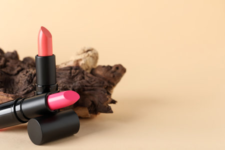 Beautiful pink lipsticks on beige background, space for textの写真素材