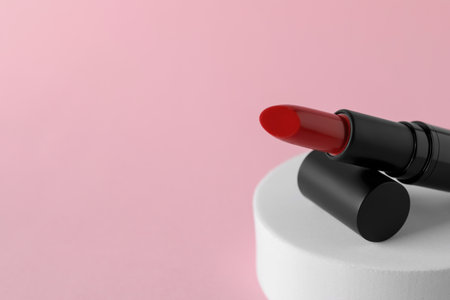 Beautiful glossy red lipstick on pink background, closeup. Space for textの写真素材
