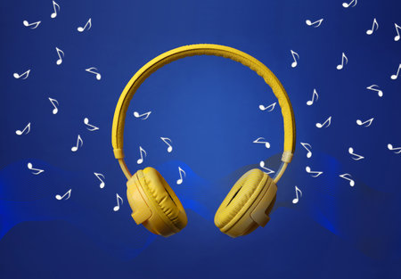 Yellow headphones and flying music notes on blue backgroundの写真素材