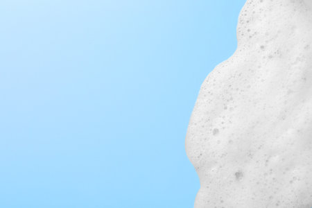 Foam sample on light blue background, top view. Space for text