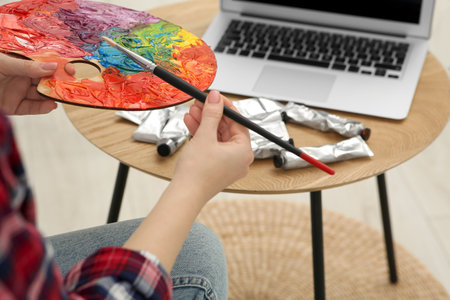 Woman learning to paint with online course at home, closeup. Time for hobbyの写真素材