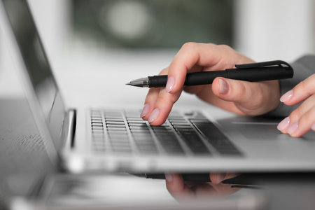 Woman working on laptop at table, closeup. Electronic document managementの写真素材