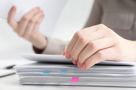 Woman reading documents at wooden table in office, closeupの写真素材