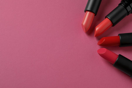 Beautiful lipsticks on pink background, flat lay. Space for textの写真素材