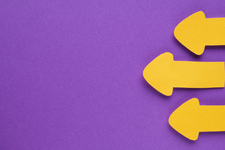 Paper arrows on purple background, flat lay. Space for text
