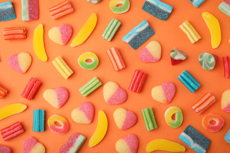 Many different jelly candies on orange background, flat layの写真素材