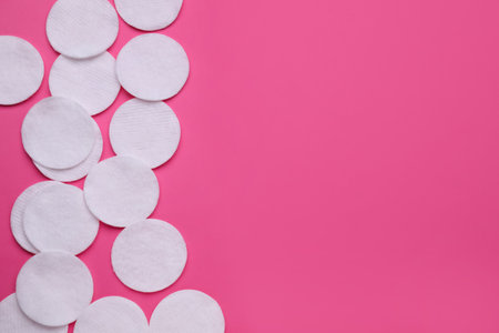 Clean cotton pads on pink background, flat lay. Space for textの写真素材