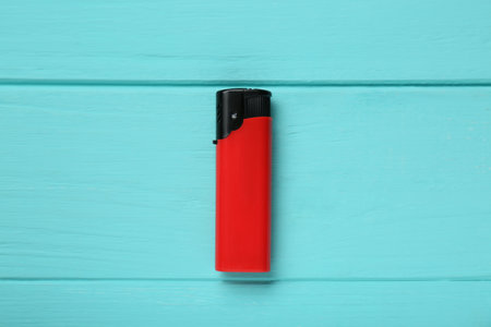 Stylish small pocket lighter on turquoise wooden background, top viewの写真素材