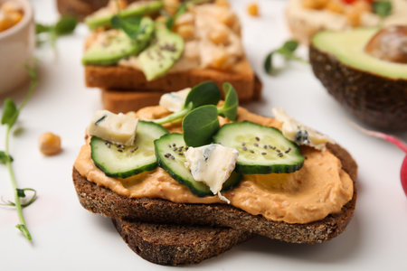 Delicious sandwich with hummus and ingredients on white table, closeupの写真素材