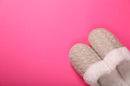 Pair of beautiful soft slippers on pink background, top view. Space for textの写真素材