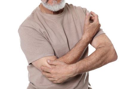 Senior man suffering from pain in elbow on white background, closeup. arthritis symptomsの写真素材