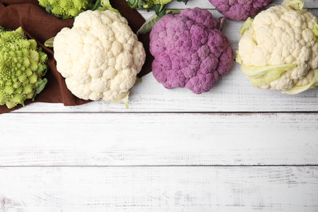 Different fresh cabbages on white wooden table, flat lay. Space for textの写真素材