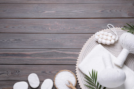 Flat lay composition of herbal bags and spa products on gray wooden table, space for textの写真素材
