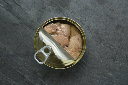Open tin can of tasty cod liver on black table, top viewの写真素材