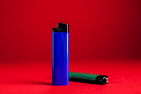 Stylish small pocket lighters on red backgroundの写真素材