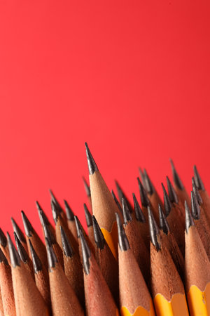 Sharp graphite pencils on red background, space for textの写真素材