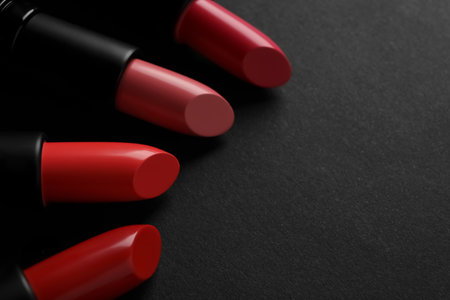 Beautiful lipsticks on black background, closeup. Space for textの写真素材