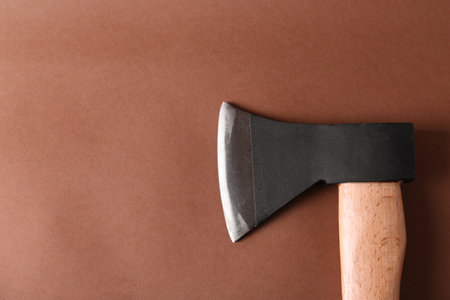 Ax with wooden handle on brown background, top view. Space for textの写真素材
