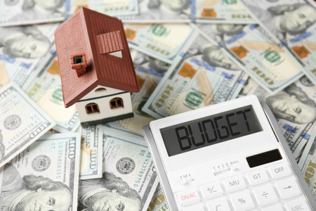 budget plan. Calculator and house model on dollar banknotesの写真素材