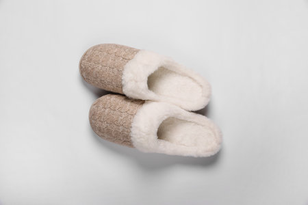 Pair of beautiful soft slippers on white background, top view