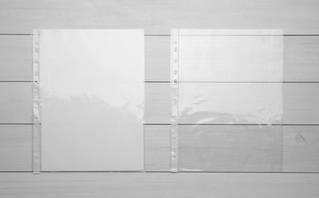 Punched pockets on white wooden table, flat layの写真素材