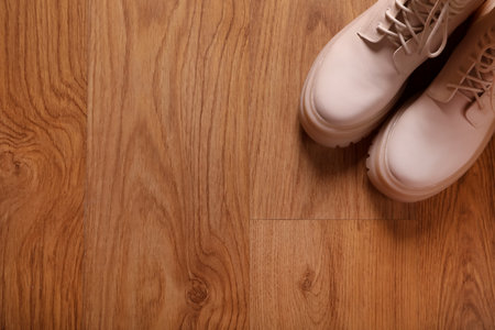 Pair of stylish beige leather shoes on wooden floor, top view. Space for textの写真素材