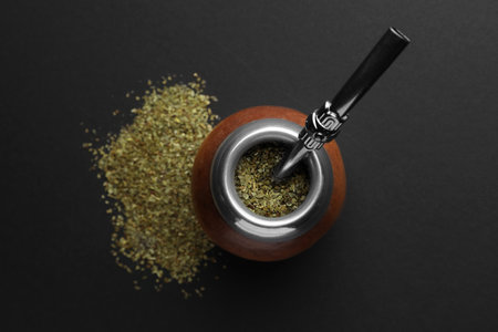 Calabash with mate tea and bombilla on black table, flat layの写真素材