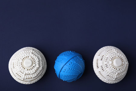 Laundry dryer balls on dark blue background, flat lay. Space for textの写真素材