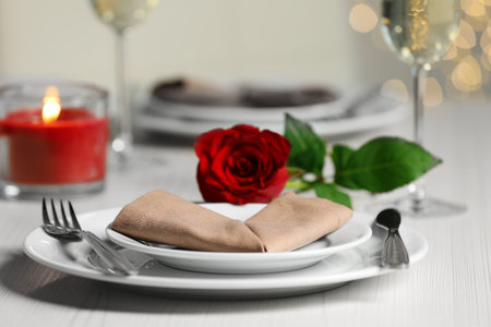 Beautiful table setting with burning candle and rose for romantic dinner, closeupの写真素材