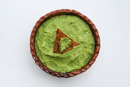 Delicious guacamole made of avocados with nachos on white background, top viewの写真素材