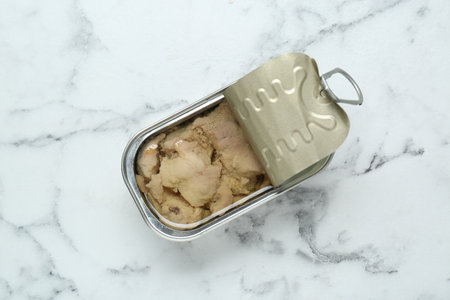 Open tin can of tasty cod liver on white marble table, top viewの写真素材