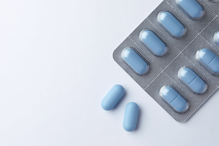 Pills and space for text on white background, top view. Potency problemの写真素材