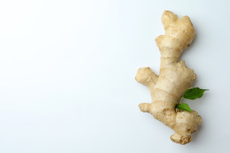 Fresh ginger with green leaves on white background, top view. Space for textの写真素材