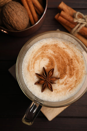 Delicious eggnog with spices on wooden table, flat layの写真素材