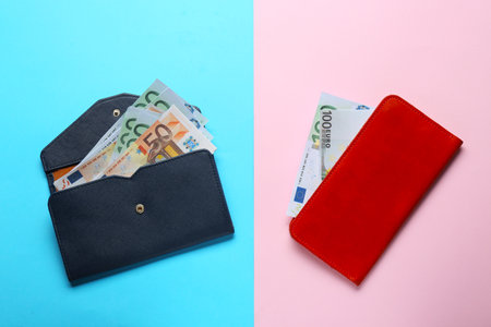 gender pay gap. Wallets with banknotes on color background, flat lay