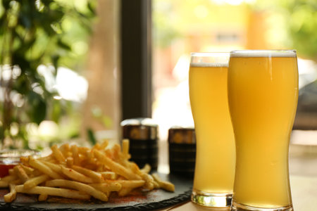 Delicious hot french fries and beer served on tableの写真素材