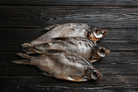 Tasty dried fish on black wooden table, flat layの写真素材